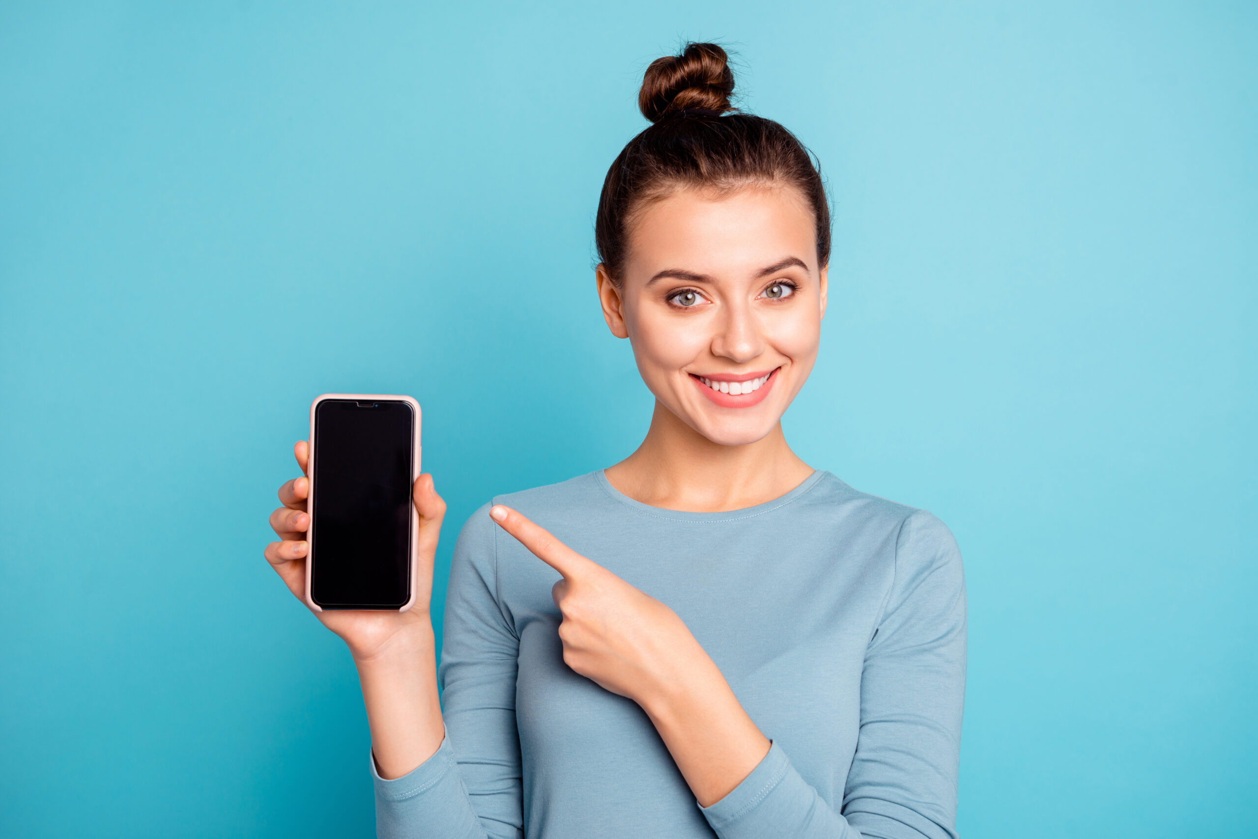 Close-up portrait of her she nice-looking attractive sweet lovely cheerful teenage girl holding in hand new cool buying purchase ad advert isolated over bright vivid shine turquoise background